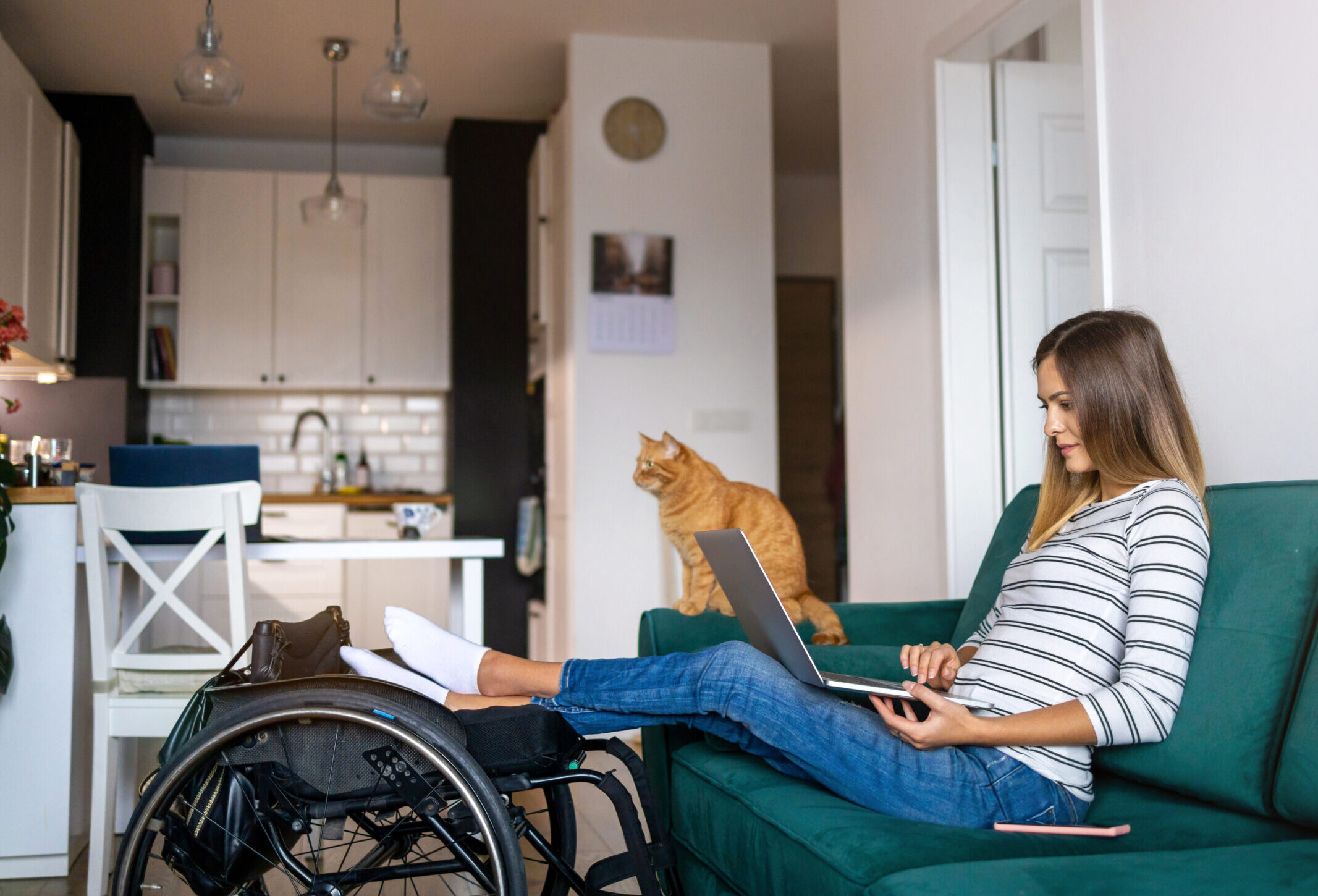 woman sitting on living counc with feet propped up on her wheelchair