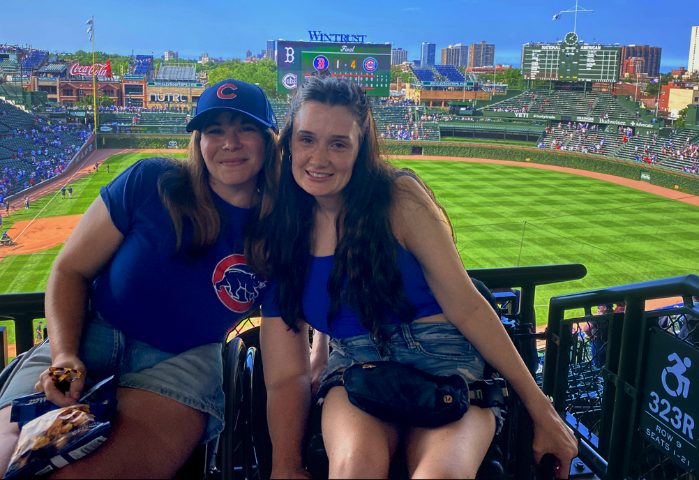 two women in accessible seating section with Wrigley field in the background